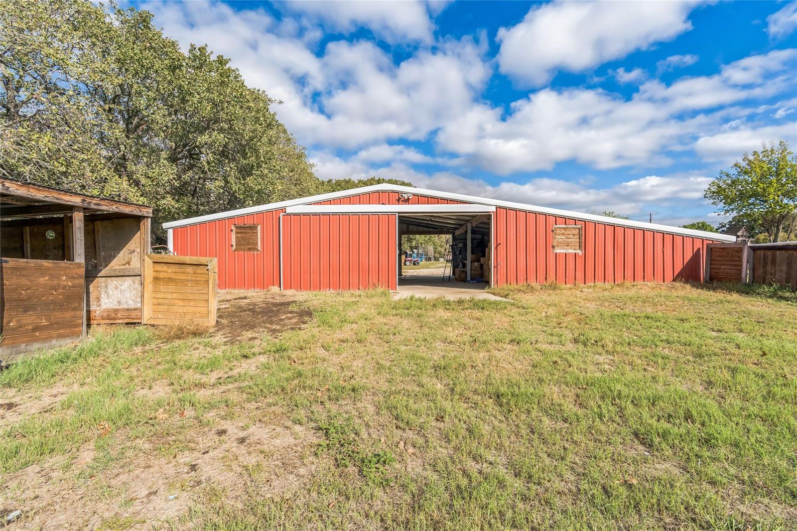 Large red barn with pens, on the property's pasture