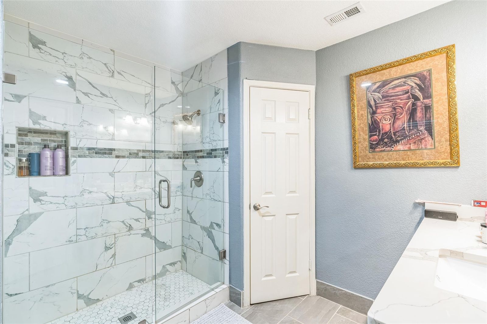 Glass shower with marble-look tile